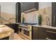 Kitchen featuring modern stainless steel range, fluted range hood, and stone counters and backsplash at 7733 Pointe Venezia Dr, Orlando, FL 32836