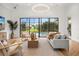 Light-filled living room featuring a backyard view, comfortable seating, and herringbone wood floors at 7733 Pointe Venezia Dr, Orlando, FL 32836