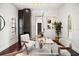 Bright home office with a glass desk, designer chairs, and dark hardwood floors at 7733 Pointe Venezia Dr, Orlando, FL 32836