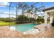 A screened-in pool area features brick pavers and access to a hot tub at 7733 Pointe Venezia Dr, Orlando, FL 32836