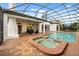 Backyard oasis with large swimming pool, attached spa, brick patio, and covered seating area for entertaining at 7733 Pointe Venezia Dr, Orlando, FL 32836