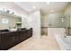 Bathroom featuring a double vanity, glass-enclosed shower, a soaking tub, and tile floors at 800 Hamilton Place Ct, Winter Park, FL 32789
