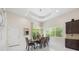 Elegant dining room with a modern chandelier, a view of the lush outdoors, and stylish furniture at 800 Hamilton Place Ct, Winter Park, FL 32789