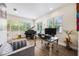 Bright home office with grand piano, black desk, and large windows overlooking greenery at 800 Hamilton Place Ct, Winter Park, FL 32789