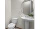 Elegant powder room featuring a pedestal sink, round mirror and toilet with neutral paint at 8113 Key West Dove St, Winter Garden, FL 34787