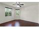 Bright bedroom with dark wood floors and windows offering views of lush greenery at 8113 Key West Dove St, Winter Garden, FL 34787