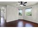 Bright bedroom with dark wood floors, ceiling fan and windows offering views of lush greenery at 8113 Key West Dove St, Winter Garden, FL 34787