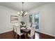 Elegant dining room features a wooden table, upholstered chairs, stylish chandelier, and natural light from the sliding glass doors at 8113 Key West Dove St, Winter Garden, FL 34787