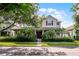 Beautiful two-story home with a cozy front porch, red shutters, and mature trees providing ample shade at 8113 Key West Dove St, Winter Garden, FL 34787