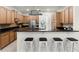 Modern kitchen featuring dark countertops, maple cabinets, bar seating, and stainless-steel appliances, perfect for entertaining at 8113 Key West Dove St, Winter Garden, FL 34787