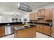 Modern kitchen featuring granite countertops, an island with a sink, and an eye-catching pot rack at 8113 Key West Dove St, Winter Garden, FL 34787