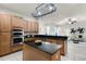 Well-appointed kitchen with dark countertops, stainless steel appliances, ample cabinet space, and an open layout leading to living area at 8113 Key West Dove St, Winter Garden, FL 34787