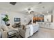 Spacious living room with tile flooring, ceiling fan, television, leading to the kitchen with bar seating at 8113 Key West Dove St, Winter Garden, FL 34787