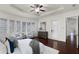 Bright and airy primary bedroom boasts tray ceiling, ample windows, and dark wood floors at 8113 Key West Dove St, Winter Garden, FL 34787