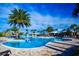 Community pool area with palm trees, lounge chairs, and a clubhouse in the background at 8113 Key West Dove St, Winter Garden, FL 34787