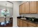 Convenient wet bar with granite countertops, wooden cabinets, and a view into the adjacent dining room at 8113 Key West Dove St, Winter Garden, FL 34787