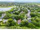 This aerial view shows a home nestled among lush trees in a peaceful neighborhood near a tranquil lake at 871 Paddington Ter, Lake Mary, FL 32746