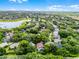 This aerial view shows a home nestled among lush trees in a peaceful neighborhood near a tranquil lake at 871 Paddington Ter, Lake Mary, FL 32746