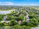 This aerial view shows a home nestled among lush trees in a peaceful neighborhood near a tranquil lake at 871 Paddington Ter, Lake Mary, FL 32746