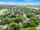 This aerial view shows a home nestled among lush trees in a peaceful neighborhood near a tranquil lake at 871 Paddington Ter, Lake Mary, FL 32746