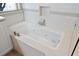 Bright bathroom featuring a tiled whirlpool tub, subway tile backsplash, and window offering natural light at 871 Paddington Ter, Lake Mary, FL 32746