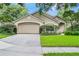 Well-maintained single-story home with a two-car garage, landscaped yard, and inviting curb appeal in a lush, green setting at 871 Paddington Ter, Lake Mary, FL 32746