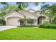 Inviting single-story home with a landscaped front yard, attached garage, and mature trees providing shade and curb appeal at 871 Paddington Ter, Lake Mary, FL 32746