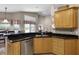 Well-equipped kitchen with stainless steel appliances, dark granite countertops, and wooden cabinets at 871 Paddington Ter, Lake Mary, FL 32746