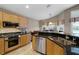 Kitchen boasts stainless appliances, granite counters, tile backsplash, and light wood cabinetry at 871 Paddington Ter, Lake Mary, FL 32746