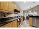 Kitchen boasts stainless appliances, granite counters, tile backsplash, and light wood cabinetry at 871 Paddington Ter, Lake Mary, FL 32746