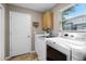 Functional laundry room with a utility sink, washer, dryer, and storage cabinet at 871 Paddington Ter, Lake Mary, FL 32746