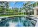 A view of an enclosed swimming pool and patio in a well landscaped yard at 871 Paddington Ter, Lake Mary, FL 32746