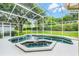 A screened in swimming pool with spa and luscious green landscaping at 871 Paddington Ter, Lake Mary, FL 32746
