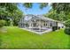 This lovely home features a screened-in pool surrounded by a lush green lawn and trees at 871 Paddington Ter, Lake Mary, FL 32746