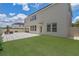 Spacious backyard featuring a patio with outdoor seating, artificial turf, and a neutral-colored stucco exterior at 9025 Horizon Pointe Trl, Windermere, FL 34786