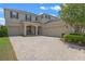 Inviting two-story home showcasing a brick driveway and well-maintained landscaping, with a two-car and one-car garage at 9025 Horizon Pointe Trl, Windermere, FL 34786