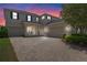 Inviting two-story home showcasing a brick driveway and well-maintained landscaping, with a two-car and one-car garage at 9025 Horizon Pointe Trl, Windermere, FL 34786
