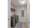 Convenient laundry room features stainless steel washer/dryer, tile floor, and overhead storage at 9025 Horizon Pointe Trl, Windermere, FL 34786