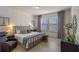 Modern primary bedroom featuring an accent wall, tiled floors, neutral colored linens, and a sitting area at 9025 Horizon Pointe Trl, Windermere, FL 34786