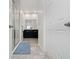 Hallway bathroom with a shower on the left, a double vanity with black cabinets at the back at 9115 Longship Aly, Orlando, FL 32832