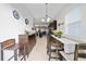 Open dining room featuring a long wooden table with seating and a bar with stools, all brightly lit at 9115 Longship Aly, Orlando, FL 32832