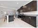 Modern kitchen featuring dark cabinets, stainless steel appliances, and an island with seating at 9115 Longship Aly, Orlando, FL 32832