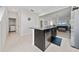 Kitchen island featuring dark cabinets, granite countertops, stainless steel appliances, and open to the living room at 9115 Longship Aly, Orlando, FL 32832