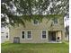 Backyard with sliding glass door, green grass, building facade and large tree at 9223 Leeland Archer Blvd, Orlando, FL 32836