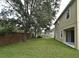 Large backyard with brick wall, mature trees, green grass and building facade at 9223 Leeland Archer Blvd, Orlando, FL 32836