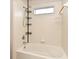 Bathtub with white tiles and shower head with window for natural light at 9223 Leeland Archer Blvd, Orlando, FL 32836