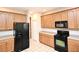 Traditional kitchen with wooden cabinets, black appliances, ample counter space, and tile floors at 9223 Leeland Archer Blvd, Orlando, FL 32836