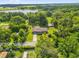 Expansive aerial view of a home surrounded by lush greenery, including a nearby lake at 1008 Bay Ave, Lake Wales, FL 33859