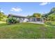View of home's back exterior with a screened porch and fenced yard at 1008 Bay Ave, Lake Wales, FL 33859