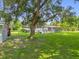 Lush backyard with mature trees, shed, and a fenced area, perfect for outdoor enjoyment at 1008 Bay Ave, Lake Wales, FL 33859
